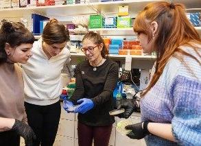 From left to right Brianna Winkler, Maria Cattell, Ph.D., Brooke Paslay and Meg Green discuss coral samples in the lab. Photo by Amanda Schwengel